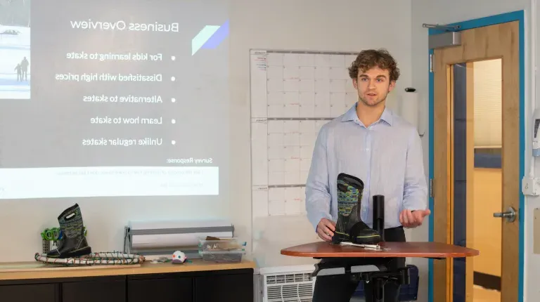 A student presents a prototype of an ice skating device