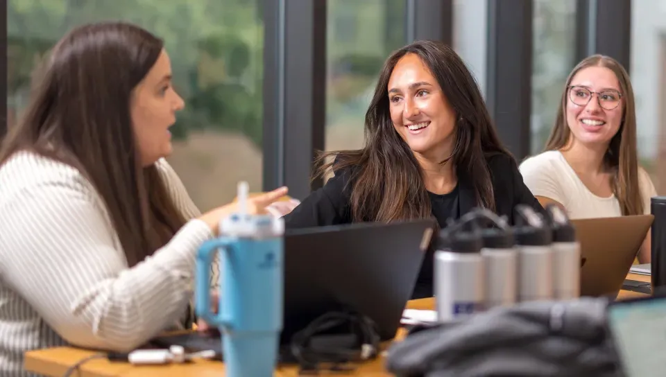 Members of the Women in Business Club talk at a conference table